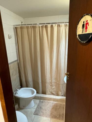 a bathroom with a toilet and a shower curtain at Mirando al canal in Ushuaia