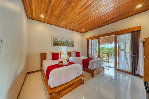 two beds in a room with a window at NG Sweet Home in Nusa Penida