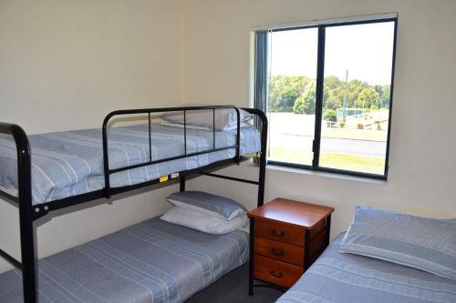two bunk beds in a room with a window at Scape Apartment 5 - Bring your own linen. in South West Rocks