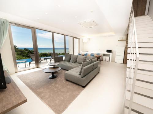 salon z kanapą i stołem w obiekcie Blue Rela Luxe Resort Okinawa w mieście Onna