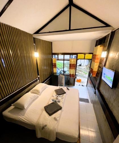 a bedroom with a large bed and a table at Tuk Tuk Guesthouse in Ko Chang