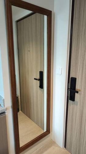 a mirror with a wooden door in a room at Anika's Staycation at BE Residence Lahug in Cebu City