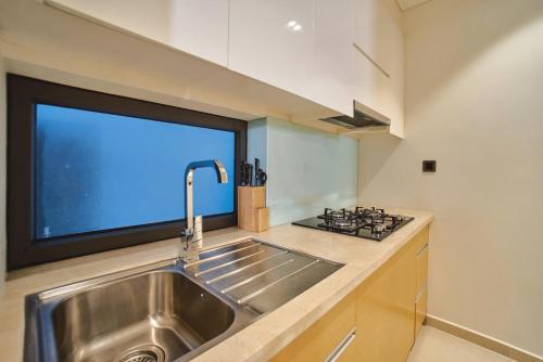 a kitchen with a sink and a large window at Clean & Quiet Villa - The Point Resort in Danang