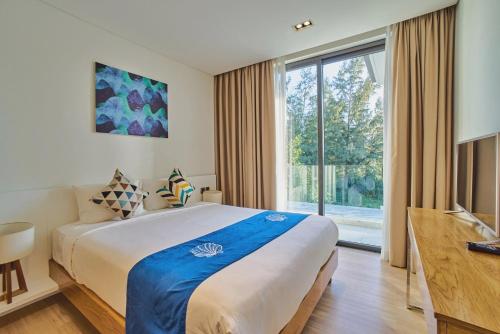 a bedroom with a large bed and a large window at Clean & Quiet Villa - The Point Resort in Danang