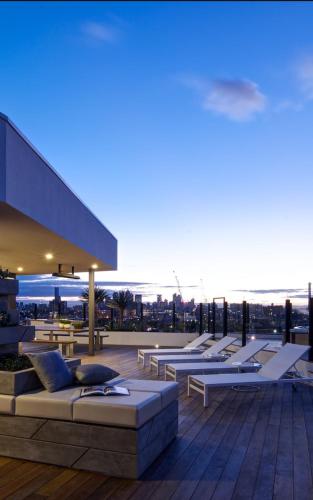 a row of lounge chairs on the roof of a building at Luxury apartment on the river with pool & Gym in Melbourne