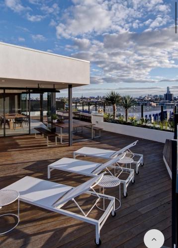 a deck with tables and chairs on a building at Luxury apartment on the river with pool & Gym in Melbourne