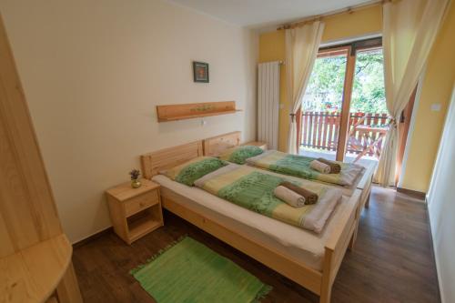 a bedroom with a large bed and a balcony at Tourist Farm Pri Kafolu in Tolmin