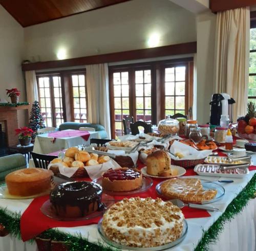 a long table filled with lots of different types of pastries at Recanto Lucerna in Campos do Jordão