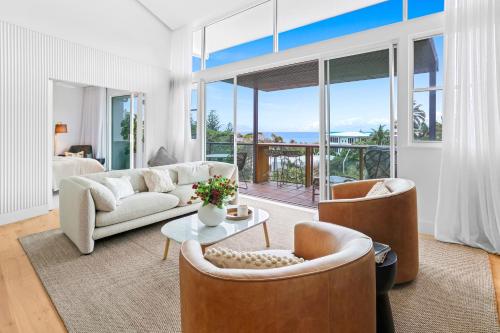 a living room with a couch and a table and chairs at Luxurious Ocean View Penthouse in Sunshine Beach