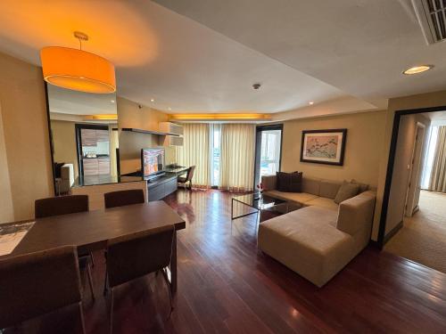 a living room with a couch and a table at The Narathiwas Hotel & Residence Sathorn Bangkok in Bangkok