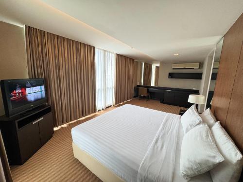 a hotel room with a bed and a flat screen tv at The Narathiwas Hotel & Residence Sathorn Bangkok in Bangkok