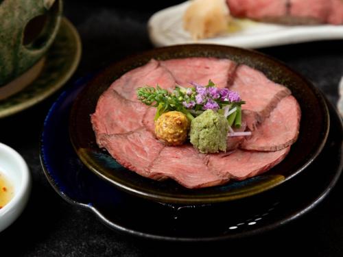 a plate of meat with vegetables on a table at Sasara in Gero