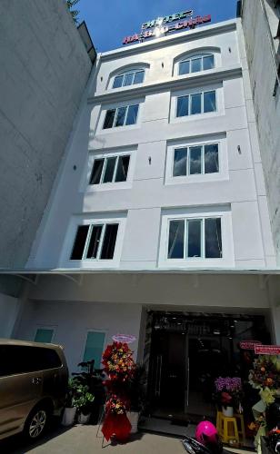 a white building with a car parked in front of it at Hà Bảo Châu 2 Hotel Tân Bình in Ho Chi Minh City