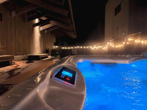 a swimming pool at night with a device in the water at Tiny N resort A棟 in Ichinomiya