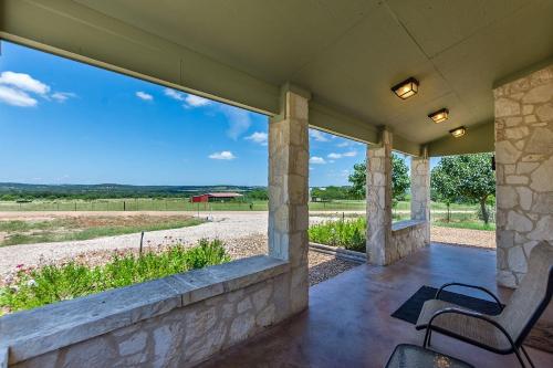 a porch with two chairs and a view of a field at Appian Way Celtic Cottage in Fredericksburg