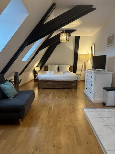 a attic bedroom with two beds and a couch at L'écume des jours in Colmar