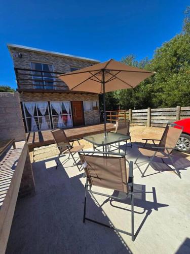 a patio with a table and chairs and an umbrella at MaryJor in La Pedrera