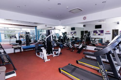 a gym with a lot of treadmills and machines at Mercure Pontianak City Center in Pontianak