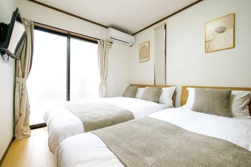 東京にあるKang's Houseの窓のある部屋にベッドが2つある