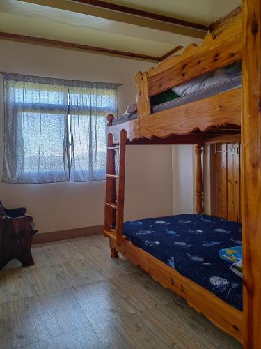 a bedroom with two bunk beds and two windows at Sea of clouds view inn in Sagada