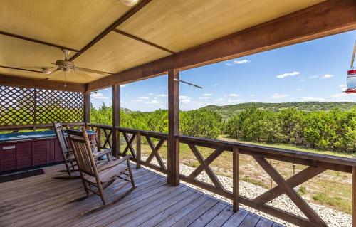 a rocking chair on a porch with a view of the mountains at Appian Way Oliva Cottage in Fredericksburg
