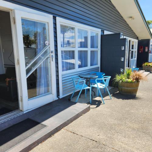 a patio with a table and chairs outside of a house at Westshore Holiday Park in Napier