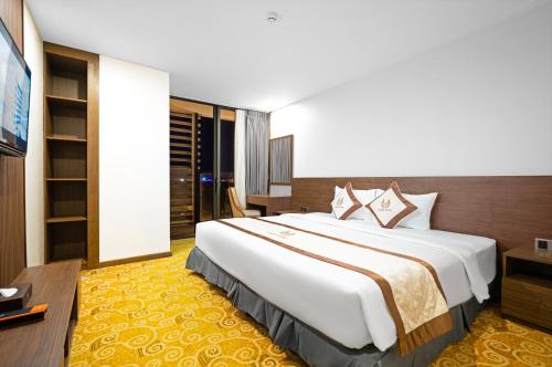 a hotel room with a large bed and a television at Vesna Hotel Nha Trang in Nha Trang