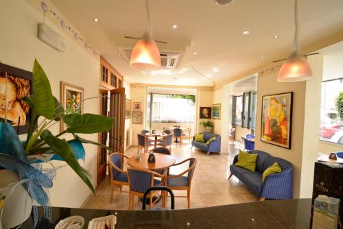 a living room with a table and chairs at Hotel Ave in Rimini