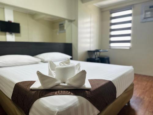 a hotel room with a bed with two folded towels at DG Budget Hotel Salem in Manila