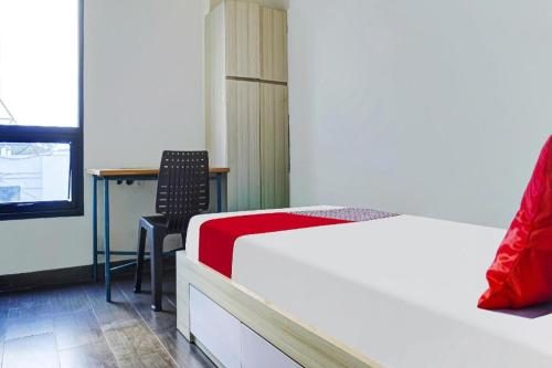 a bedroom with a bed and a desk and a table at OYO Life 91205 Rindang Guesthouse Syariah in Karawang