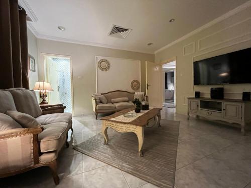 a living room with a couch and a table at Brightful and joyful 4 bedroom villa in Dubai