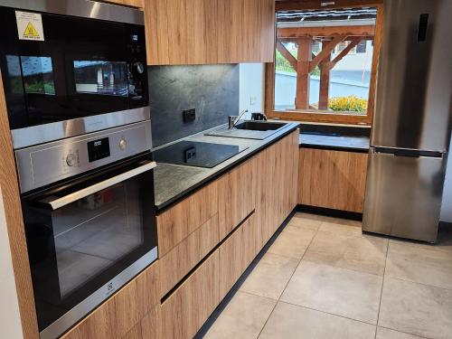 d'une cuisine équipée d'appareils en acier inoxydable et d'une fenêtre. dans l'établissement Appartement 2 pièces, 4 pers., proche centre & remontées, balcon, parking, WiFi - FR-1-676-197, à Châtel