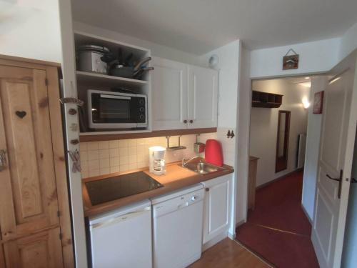 une petite cuisine avec un évier et un micro-ondes dans l'établissement Appartement rénové 2 pièces, 4 pers. à Isola 2000, proche pistes - FR-1-292-215, à Isola