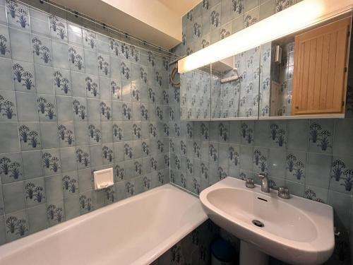 une salle de bain carrelée bleue avec un lavabo et une baignoire dans l'établissement Studio Méribel Mottaret, ski et balcon, idéal famille - FR-1-355-270, à Les Allues