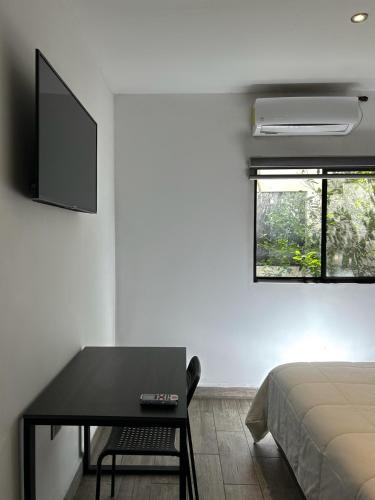 a bedroom with a bed and a table and a tv at Quinta del sol in Chihuahua