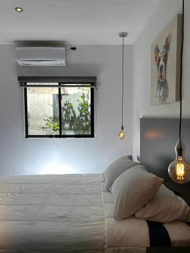 a bedroom with a large white bed with a window at Quinta del sol in Chihuahua