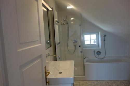 a white bathroom with a shower and a sink at Villa Bergfrieden in Oberstaufen
