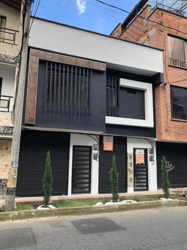 a black and white building with two trees in front of it at Apto 203 - Casa bendita in Medellín