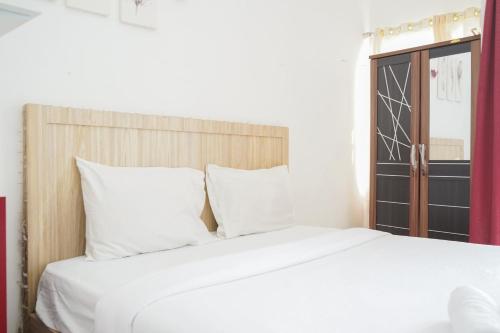 a white bed with white pillows in a room at Fully Furnished with Cozy Design Studio Poris 88 Apartment By Travelio in Tangerang