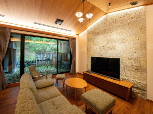 a living room with a couch and a flat screen tv at Nikko Nishimachi Club in Nikko