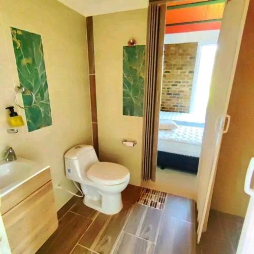 a small bathroom with a toilet and a sink at centro vacacional EL COLIBRI in San Luis de Palenque