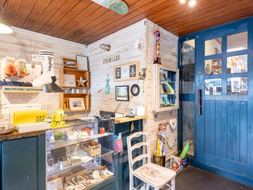 a kitchen with a blue door and a counter at Tabist Pension Third Place in Ichinomiya