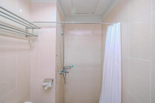 a bathroom with a shower with a shower curtain at Fully Furnished with Luxury Design Studio The Oasis Apartment By Travelio in Cikarang