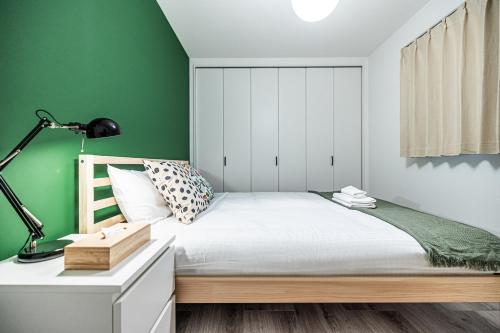 a bedroom with green walls and a bed with a desk at 住吉月满-豪华全新一户建-住吉大社6分钟-关西机场直达40分-宽敞停车位-隔壁711超市 in Osaka