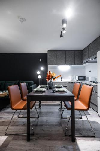 a dining room with a black table and orange chairs at 住吉月满-豪华全新一户建-住吉大社6分钟-关西机场直达40分-宽敞停车位-隔壁711超市 in Osaka