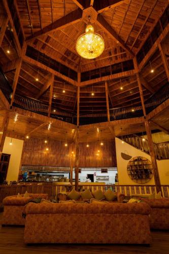 a large room with couches and a ceiling with a chandelier at Harness Zipline And Adventure Resort in Kusma