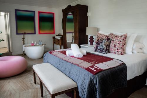 a bedroom with a large bed and a bath tub and a bath tub at The Merribee in Numba
