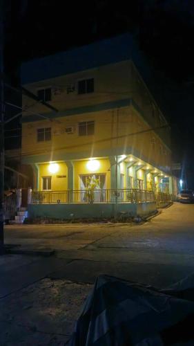 a building with lights on the side of it at night at Drossgold Pension House in Tubigon