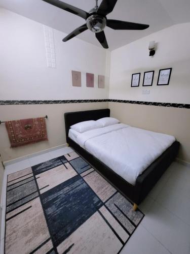 a bedroom with a bed and a ceiling fan at Homestay BAYT AL - JAZMY in Kuantan