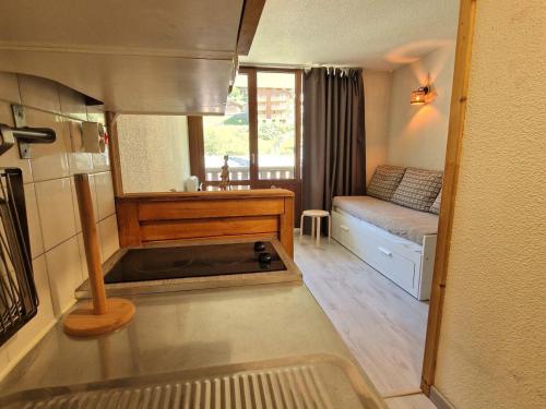 Cette petite chambre comprend un lit et un canapé. dans l'établissement Studio chaleureux 4 pers avec balcon, idéal station Valfréjus - FR-1-265-360, à Modane